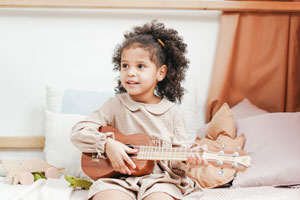 Kleines Mädchen spielt Ukulele