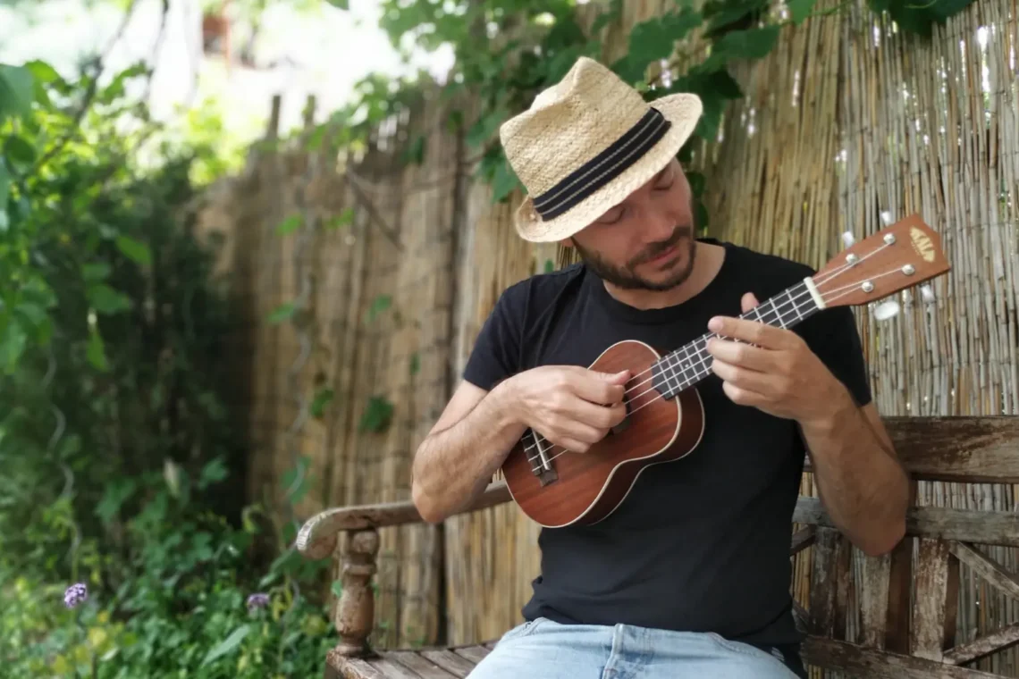 Ukulele spielen lernen – Anfänger spielt Ukulele im Garten